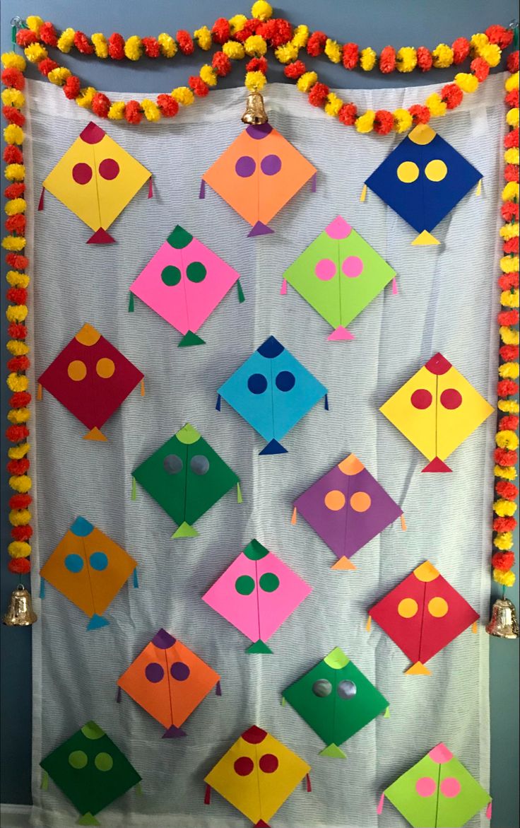 an arrangement of colorful kites hanging on a wall