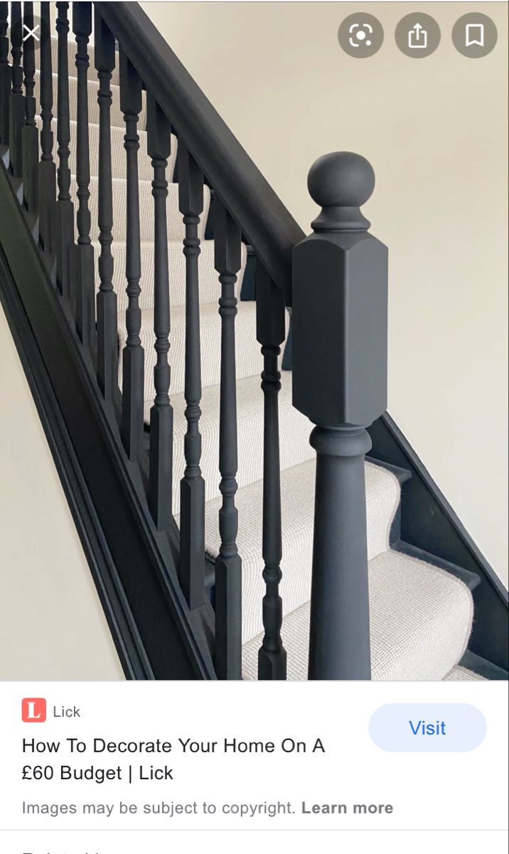 an image of a stair railing with white carpet and black baluster handrails