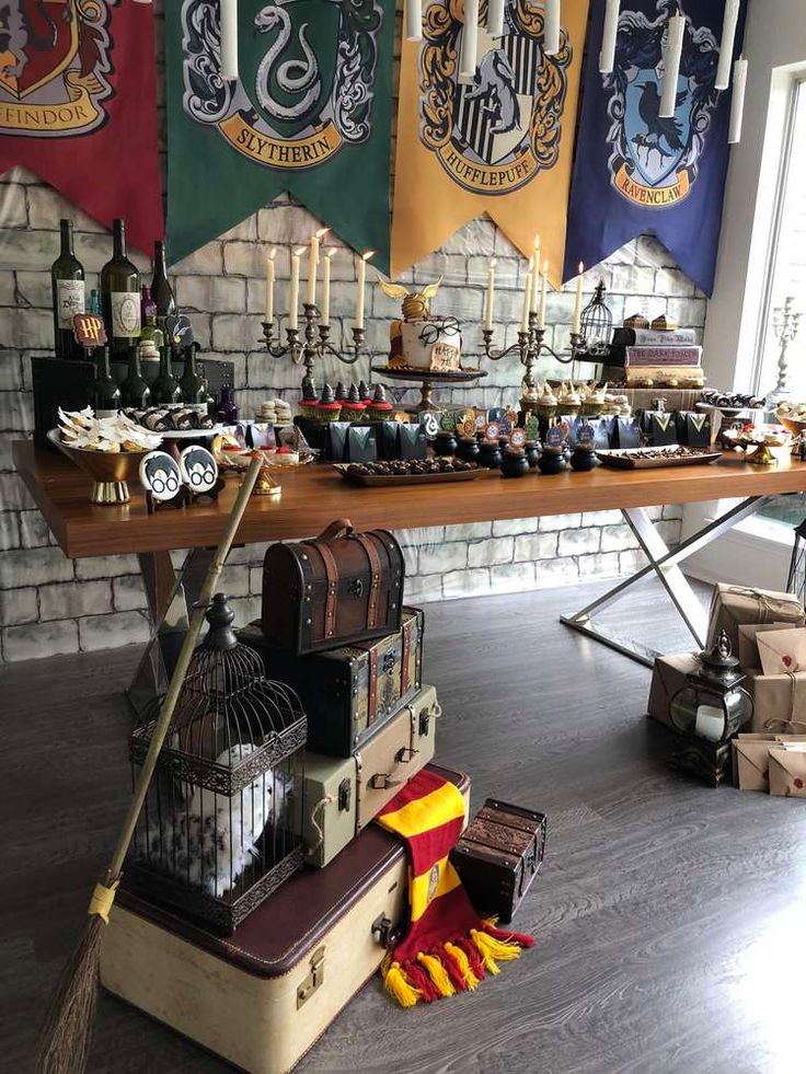 a table with harry potter flags hanging from it's sides and other decorations on the wall