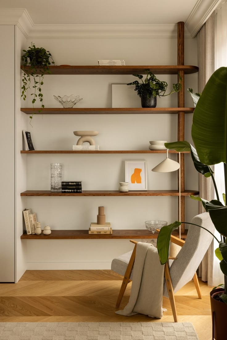 a living room filled with lots of furniture and plants on top of bookshelves