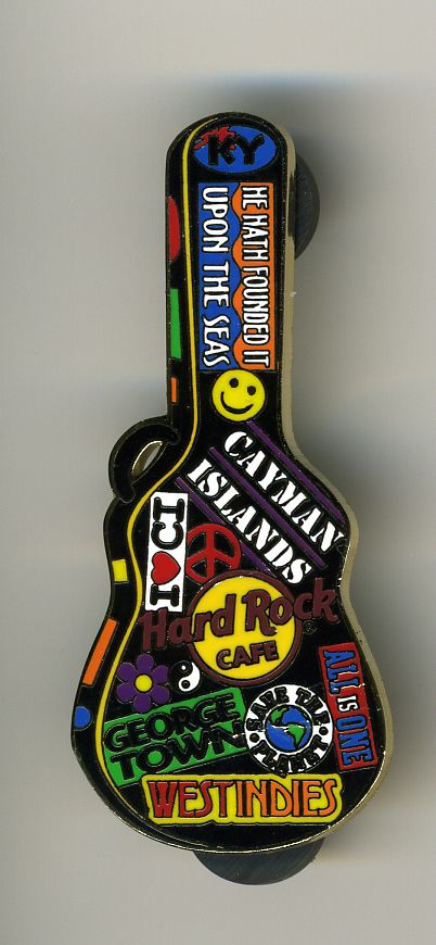 a guitar shaped keychain hanging from the side of a wall with various stickers on it