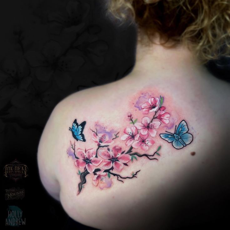 the back of a woman's shoulder with pink flowers and butterflies on her chest