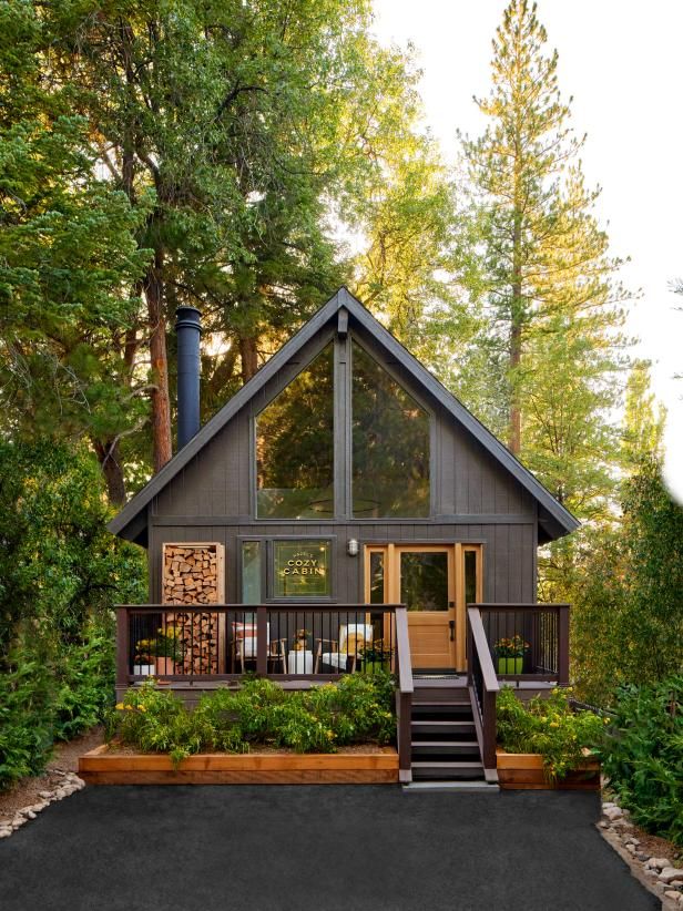 a small cabin in the woods with stairs leading up to it's front door