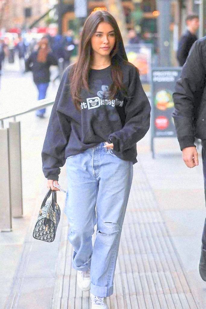 a woman walking down the street with her hand in her pocket