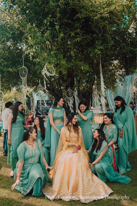 a group of women standing next to each other on top of a grass covered field