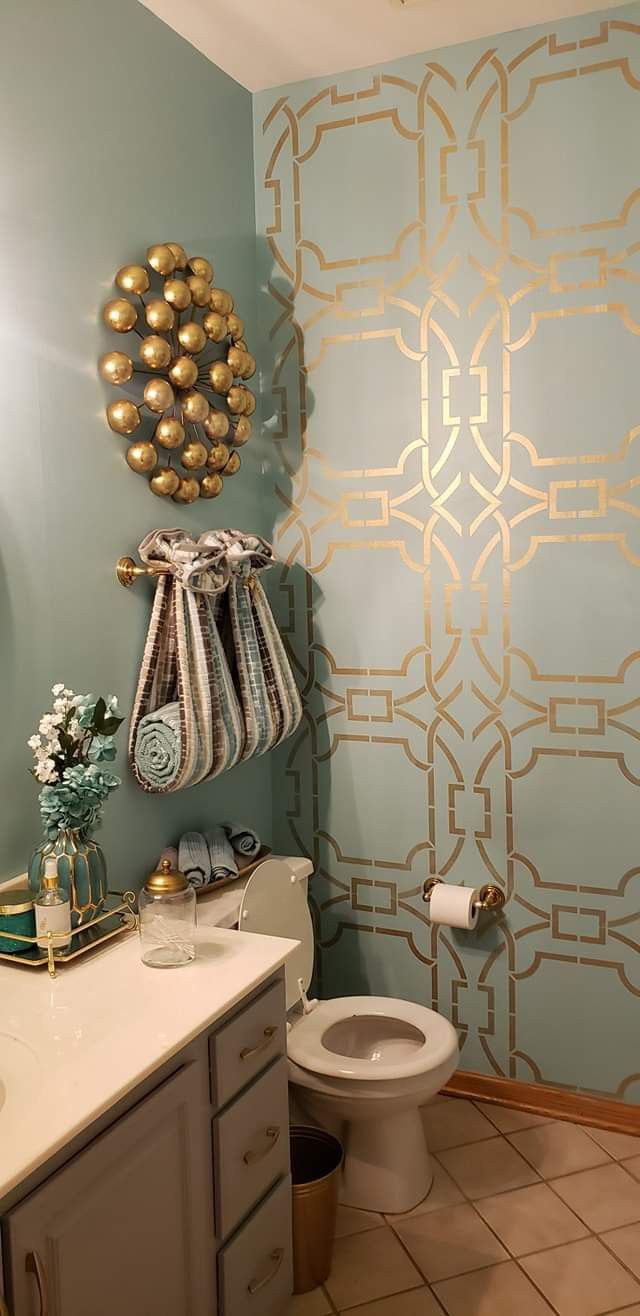 a bathroom with blue walls and gold accents