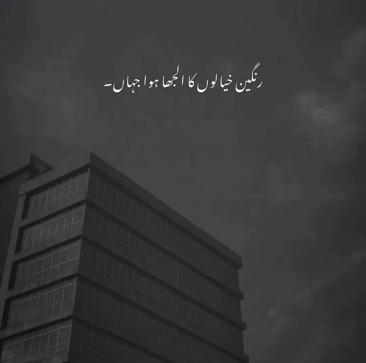 the words are written in arabic on top of a tall building with dark clouds behind it