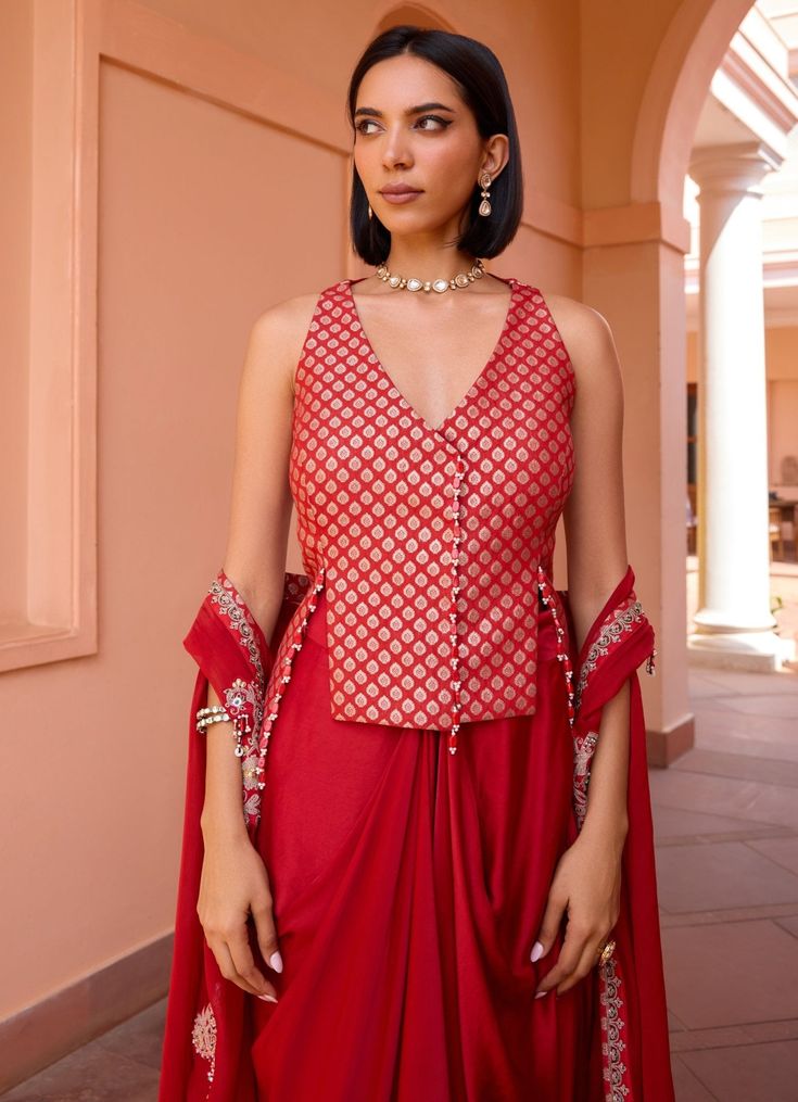 Elevate your wardrobe with this exquisite Red Embroidered Skirt Set, crafted from luxurious chanderi jacquard. The vibrant red blouse, adorned with intricate embroidery, exudes sophistication and style, making it perfect for festive occasions and special gatherings. Paired with a flowing skirt that drapes elegantly, this ensemble creates a flattering silhouette, blending traditional craftsmanship with contemporary design for a look that is both timeless and captivating. Style it with a layered c Red Designer Wear Sets With Traditional Drape, Red Traditional Drape Sets For Designer Wear, Embroidered Cotton Silk Pre-draped Saree For Party, Elegant Red Raw Silk Pre-draped Saree, Festive Brocade Pre-draped Saree For Diwali, Elegant Red Pre-draped Saree For Festive Occasions, Fitted Red Pre-draped Saree For Eid, Red Silk Fitted Pre-draped Saree, Red Cotton Silk Pre-draped Saree For Designer Wear