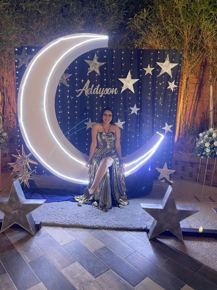 a woman standing on top of a wooden floor next to stars and a crescent sign