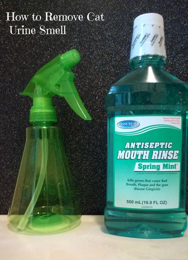 a bottle of mouth rinse next to a green sprayer on top of a counter