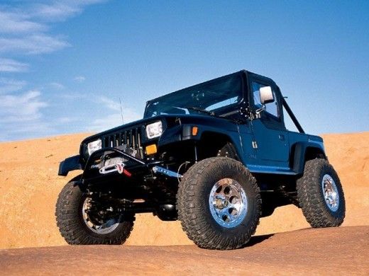 a blue jeep driving through the desert