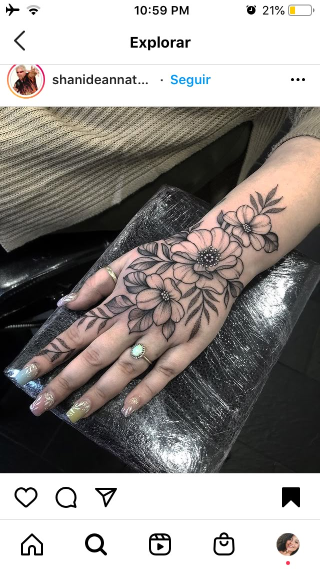 a woman's hand with flowers tattooed on it