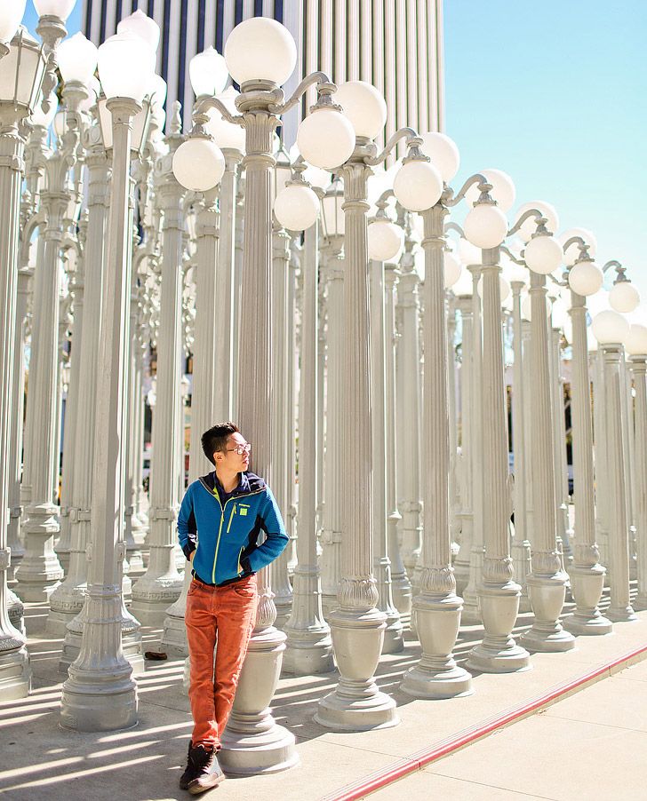 a man standing in front of many white street lamps