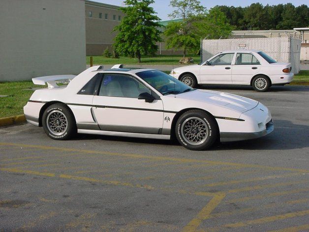 a white sports car parked in a parking lot