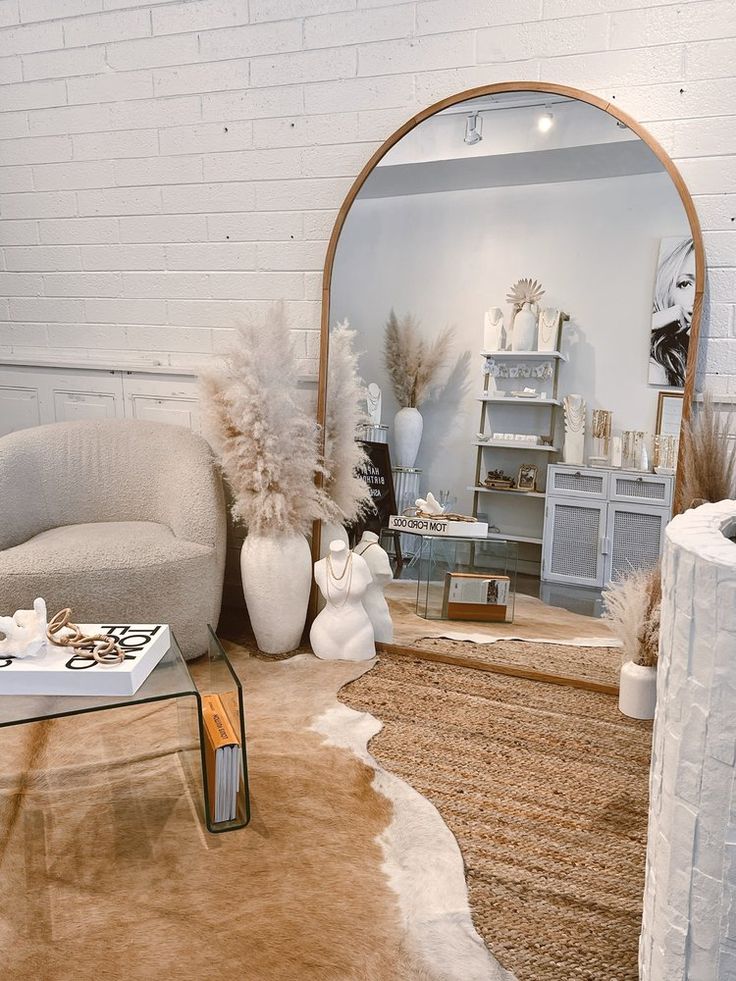 a living room filled with furniture and a large mirror on the wall above it's doorway