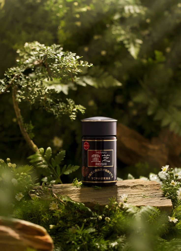 a can of coffee sitting on top of a wooden table surrounded by plants and trees