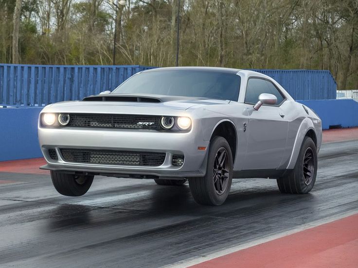 a silver car driving down a race track