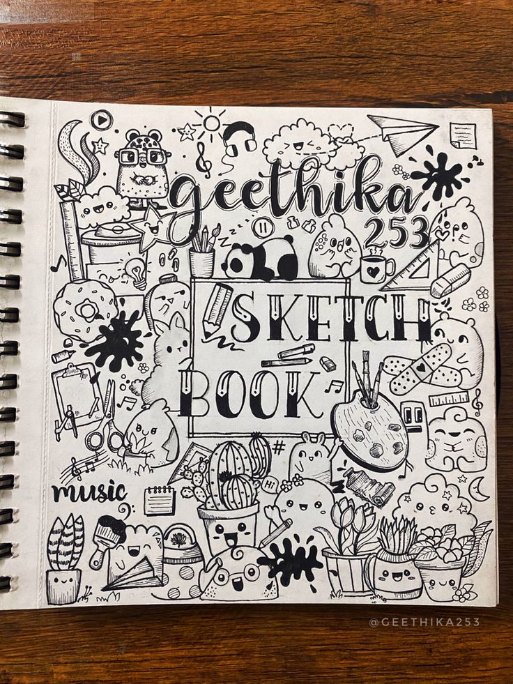 a sketch book with doodles on top of it