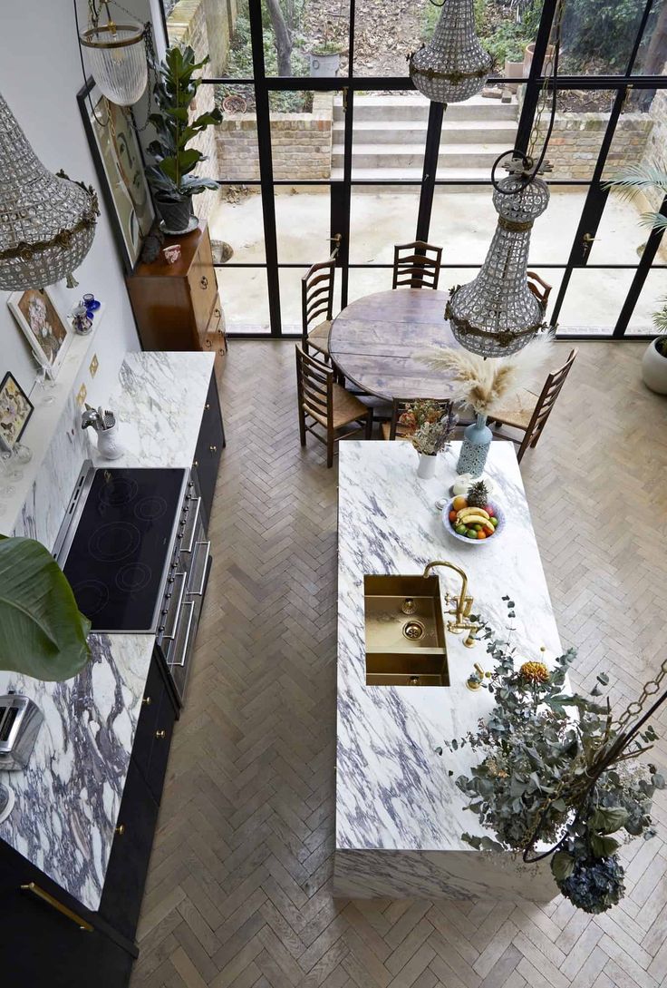 an aerial view of a kitchen with marble counter tops and island in front of the sink