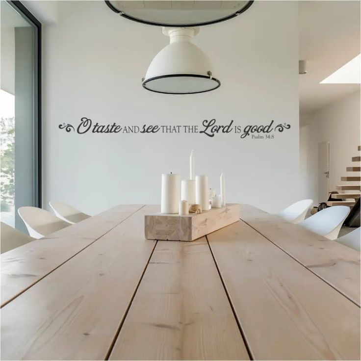 a wooden table with candles on it in front of a wall that says, create and see that the light is good