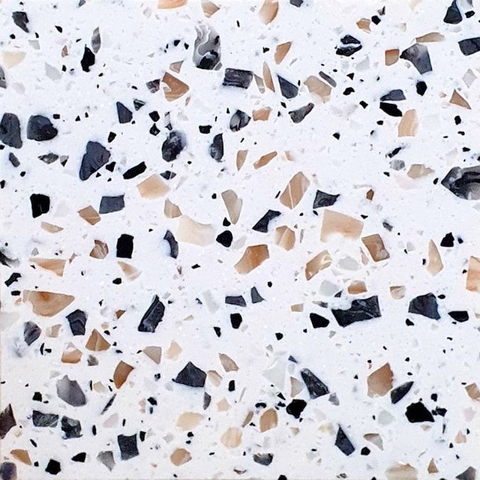 a white and black speckled surface with small pieces of glass embedded in the top