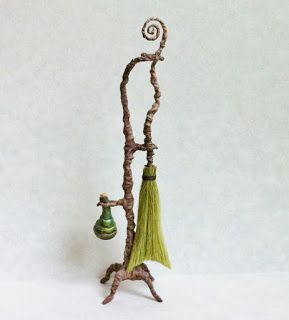 a small figurine with a green tassel hanging from it's side