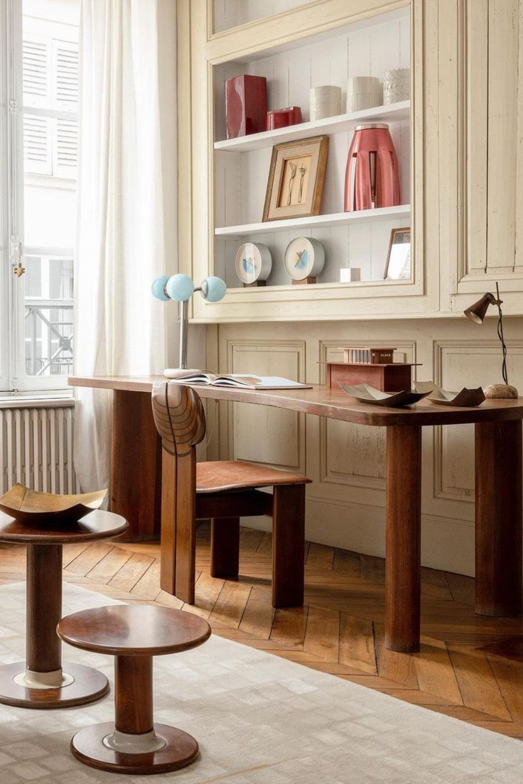 a living room filled with furniture next to a white window covered in curtains and bookshelves