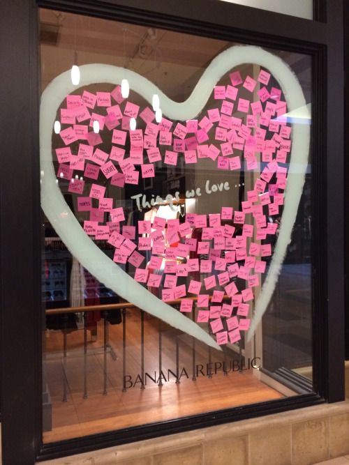 a window display with pink sticky notes in the shape of a heart