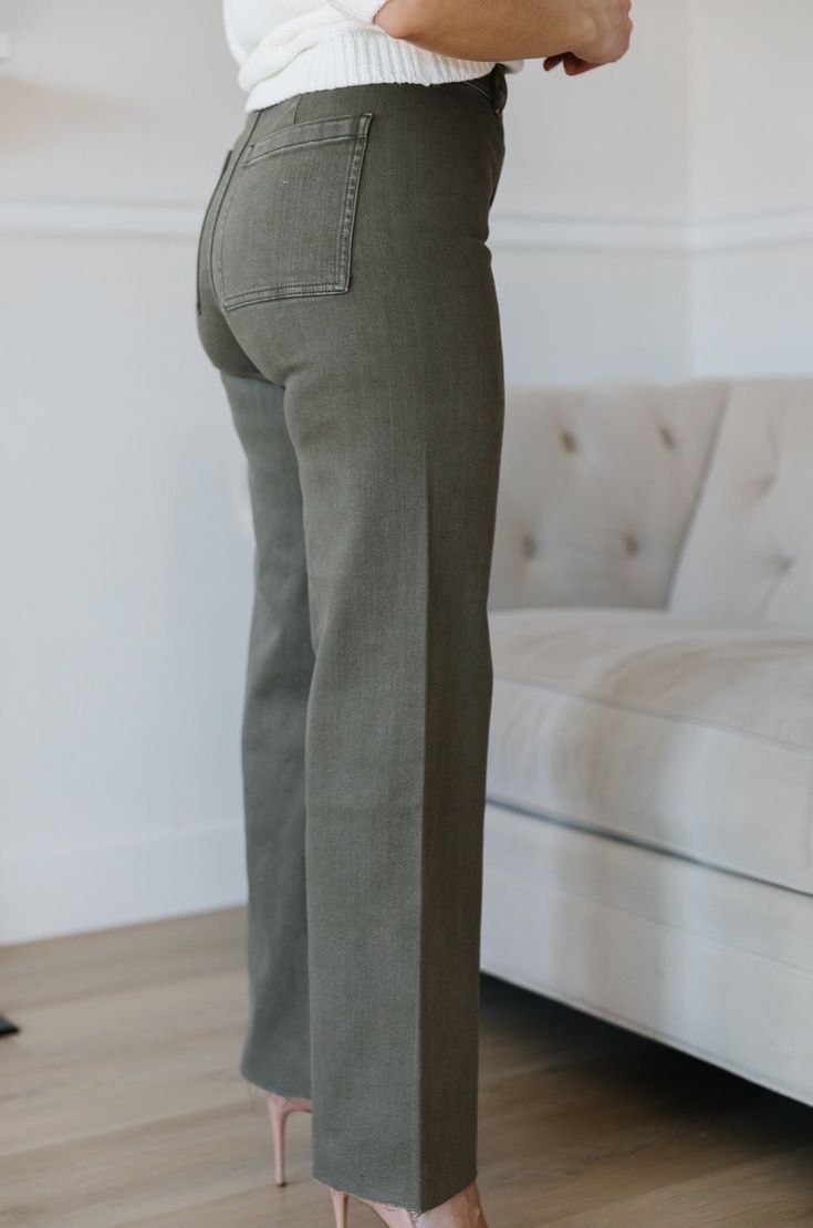 The Olive Green Wide Leg Jeans are an essential addition to any wardrobe. These classic jeans feature a flattering high waist, wide leg fit, and cropped style that flatters your figure and ensures comfort and flexibility throughout the day. Perfect for all seasons, these jeans provide timeless elegance and style. olive green wide leg pants high waist comfort stretch raw hem 98% cotton 2% spandex machine wash cold model is wearing a small SIZING CHART FOR THE JEANS: Small: fits sizing 25-26 Mediu Mid-rise Dark Wash Wide Leg Pants For Fall, Everyday Cotton Cropped Jeans For Fall, Mid-rise Wide Leg Pants For Everyday Fall Wear, Classic High Rise Wide Leg Pants, Everyday Stretch Wide Leg Jeans, Stretch Wide Leg Jeans For Everyday, High Waist Cotton Cropped Jeans, High Waist Cotton Cropped Jeans For Work, Everyday Wide Leg Flare Jeans For Fall