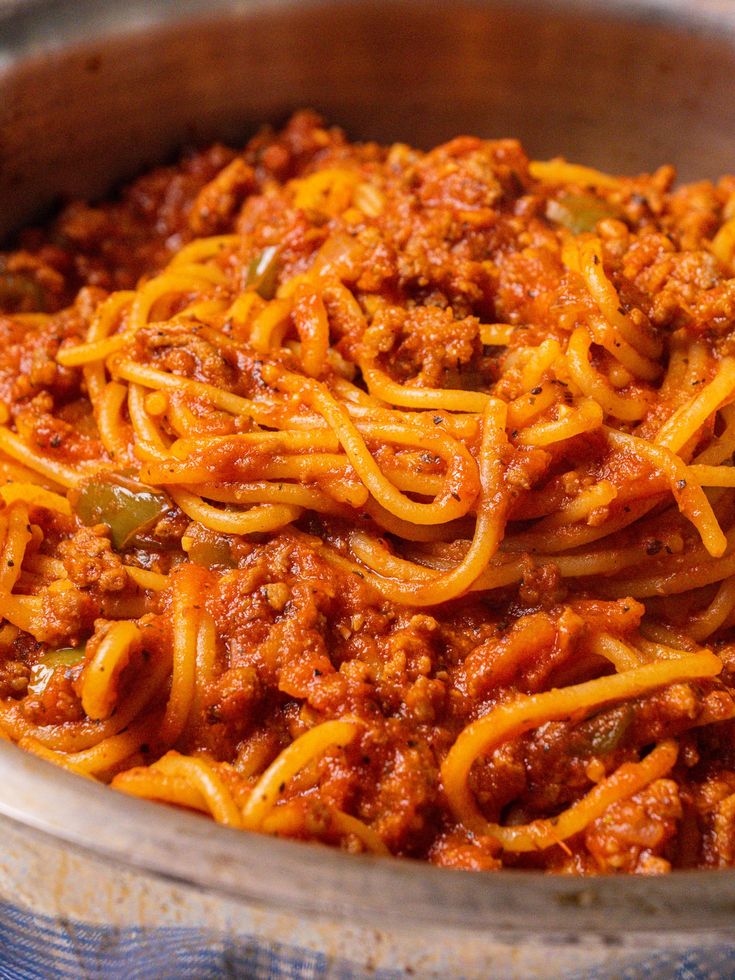 a bowl filled with spaghetti and sauce on top of a table