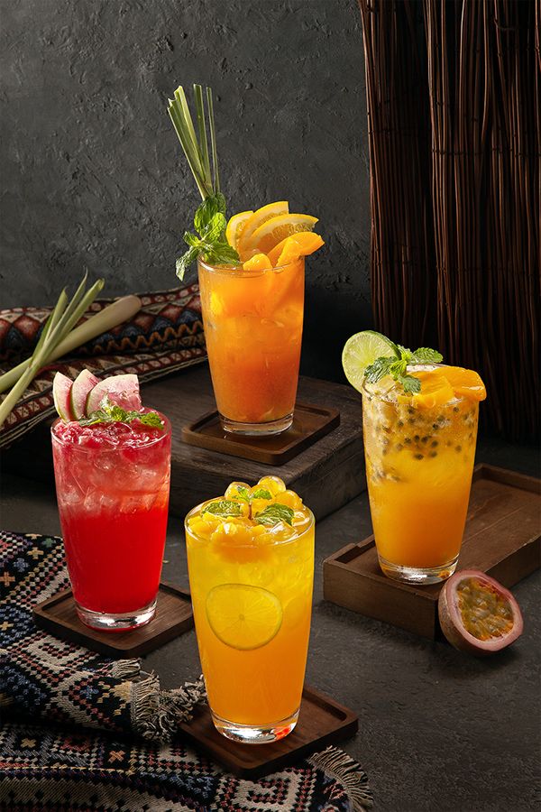 three different types of cocktails sitting on top of wooden trays next to each other