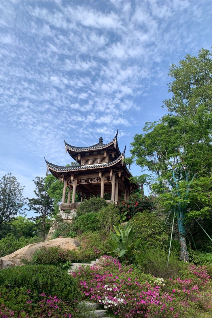 a pagoda on top of a hill surrounded by flowers