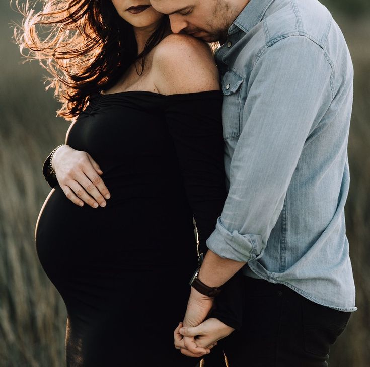 a pregnant woman holding her husband's belly