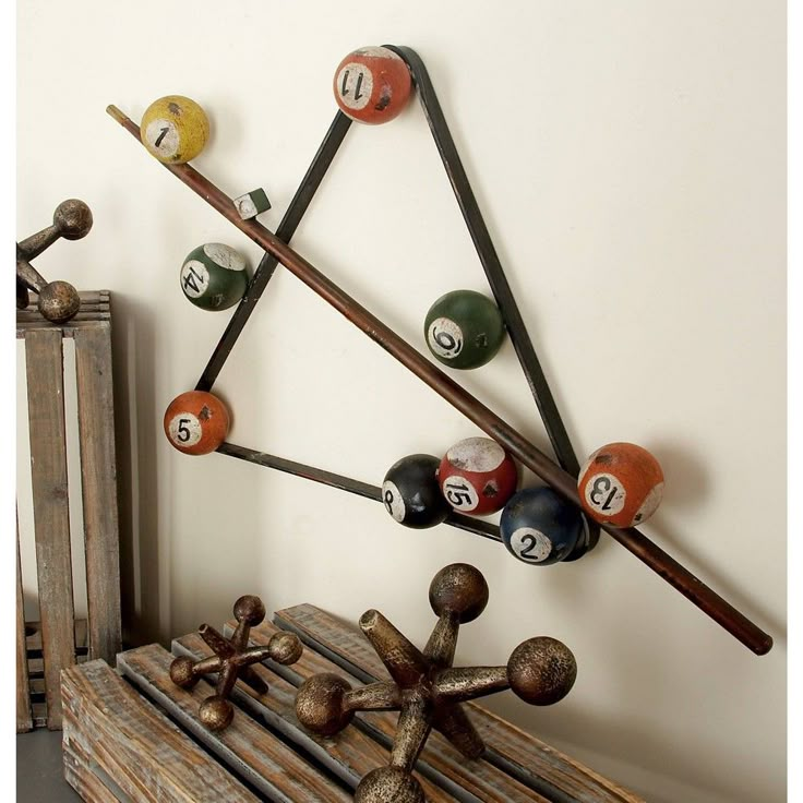 a rack with pool balls and cues on it next to a book shelf filled with books