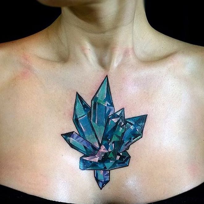 a woman with a tattoo on her chest is wearing a black top and has a blue flower