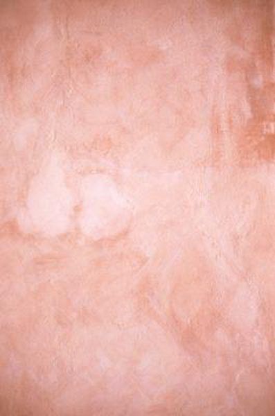 an orange and pink wall with some white paint on it