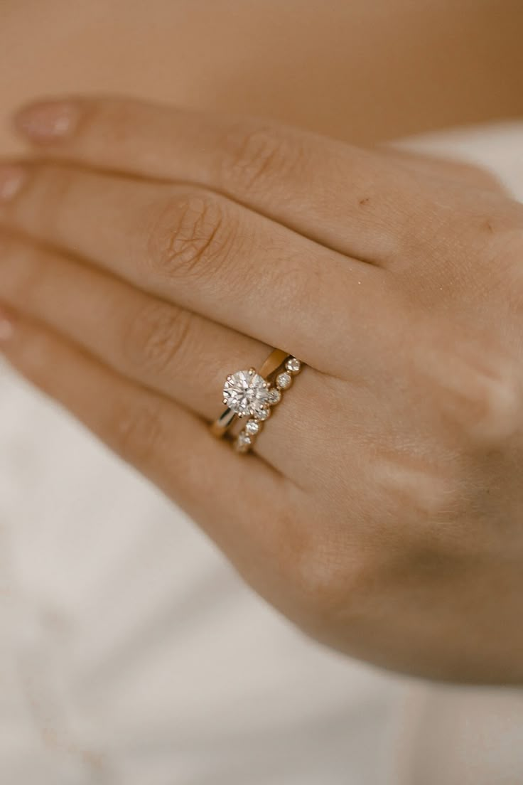 a close up of a person wearing a ring with a diamond on it's finger