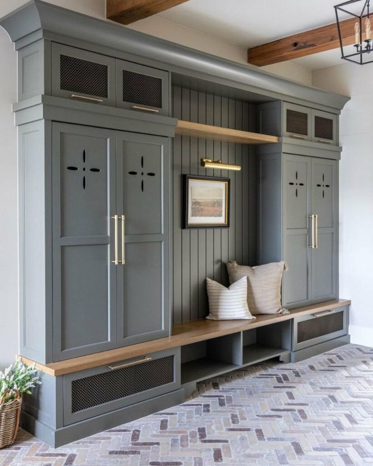 a room with gray cabinets and white pillows