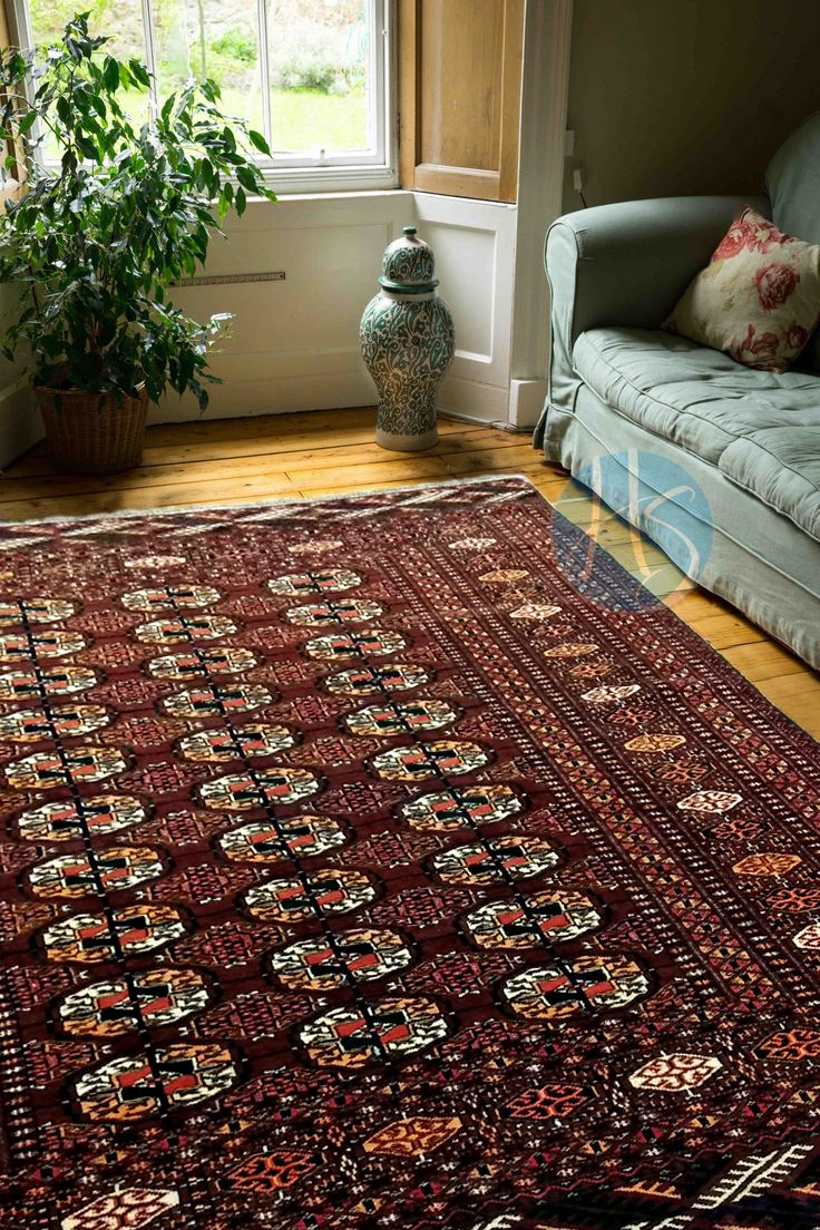 a living room area with a couch and rug on the floor next to a window