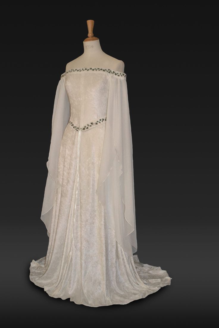 "Medieval Dress, Elvish Wedding Dress, Handfasting Dress, Elvish Gown,  Renaissance Gown, Medieval Gown, \"Guinevere\"  frockfollies is proud to add this beautiful new design to the collection. Guinevere is pure elegance in ivory crushed velvet with an elaborately embroidered off  the shoulder neckline and belt in an ivy design. It has a really romantic, elegant feel. The embroidery is in dark and light olive green. The long hanging sleeves are in ivory chiffon. The train can be made shorter at no extra cost. It is designed and custom made by Gill Linley of frockfollies. Perfect for so many occasions: Medieval, Renaissance, Elvish Weddings, Hand Fasting ceremonies, LARP events, Re Enactments, Masquerade Balls or your 'inner goddess' moments! Hand made in England by an experienced theatrica White Medieval Dress, Elvish Wedding Dress, Elvish Dress, Handfasting Dress, Elvish Wedding, Medieval Wedding Dress, Medieval Gown, Medieval Wedding, Medieval Dress