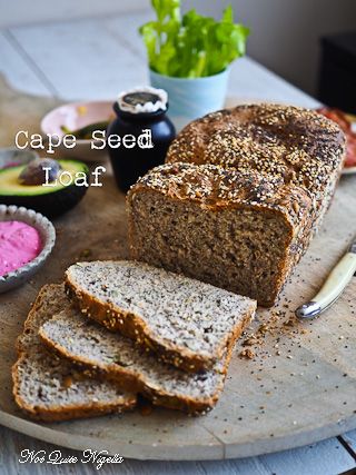 a loaf of bread sitting on top of a cutting board next to some other food