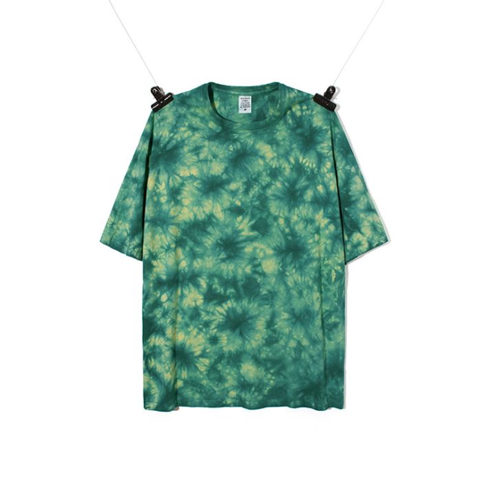 a green tie dye t - shirt hanging on a clothes line with two black clips