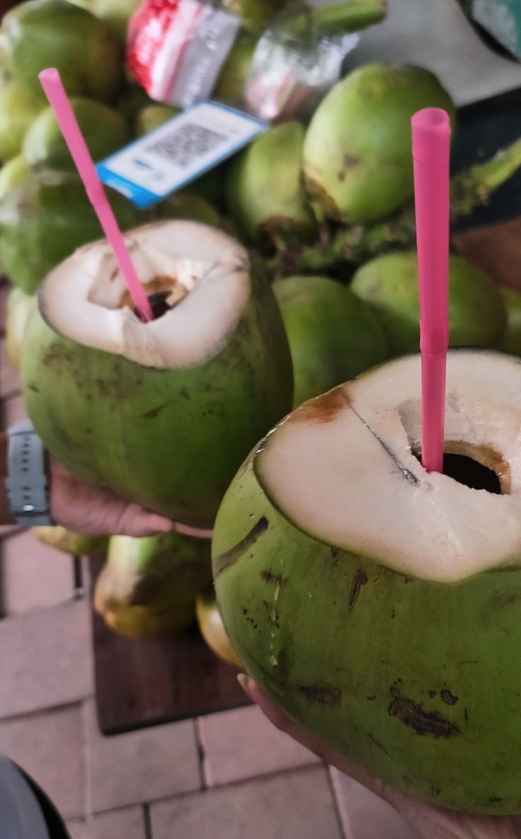 two coconuts with pink straws are on display