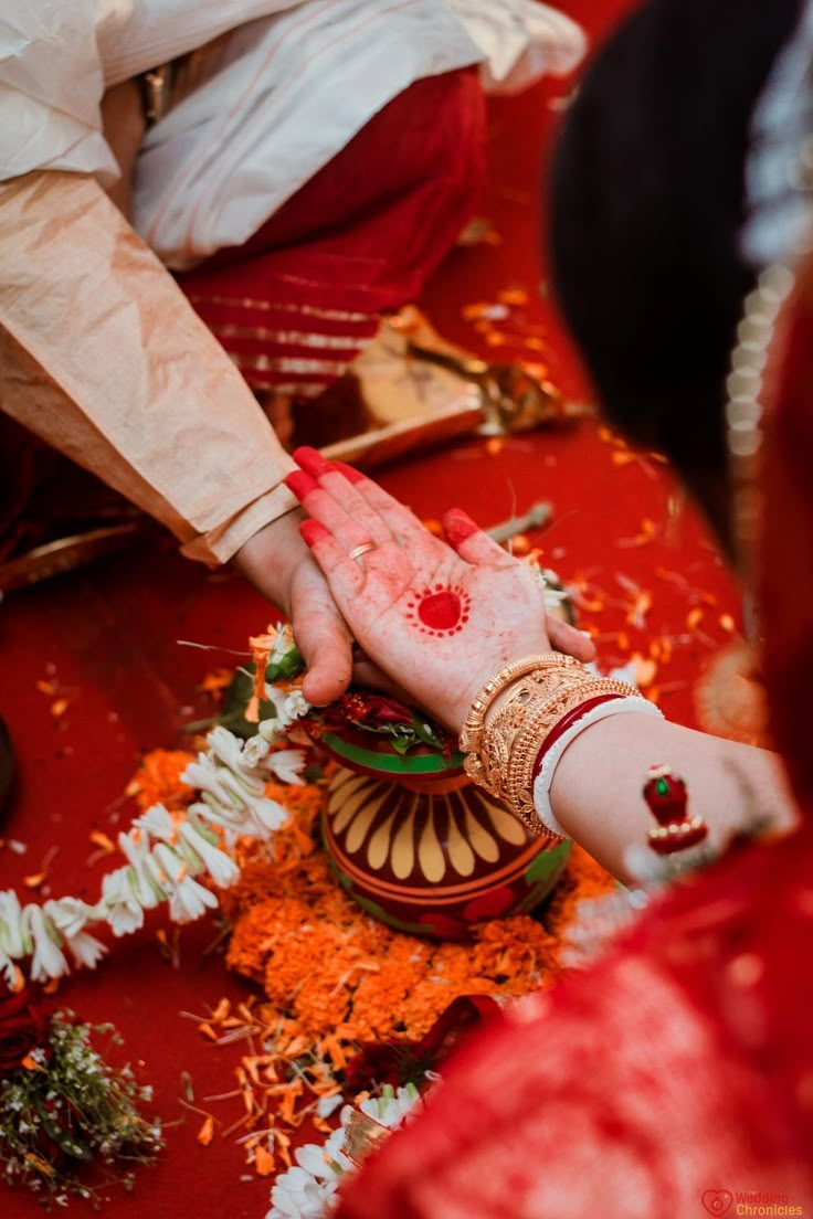 the bride and grooms hands are covered with red dye as they sit on their wedding day