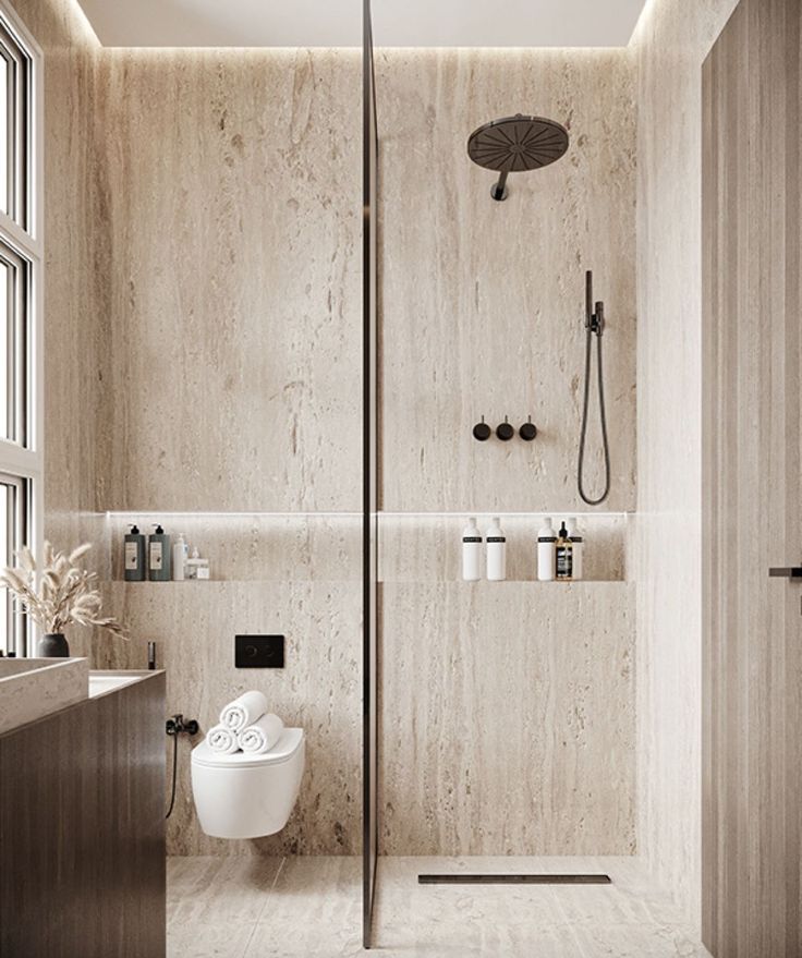 a bathroom with a walk in shower next to a toilet