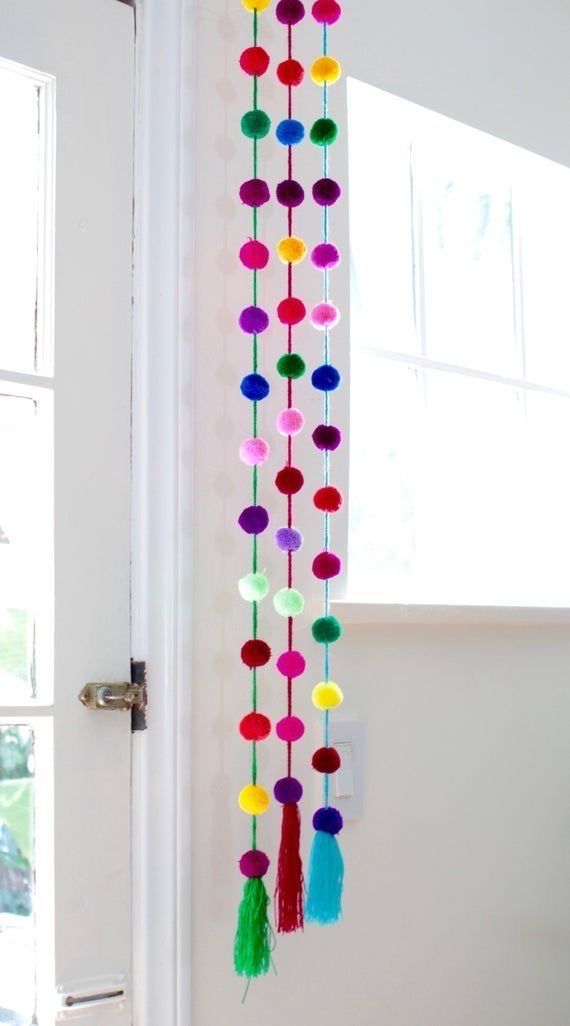 the door is decorated with colorful pom poms and tassels hanging from it