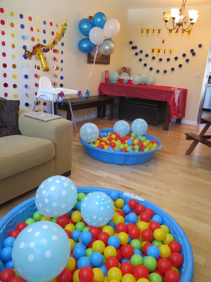 a living room filled with lots of colorful balls in a blue bowl on the floor