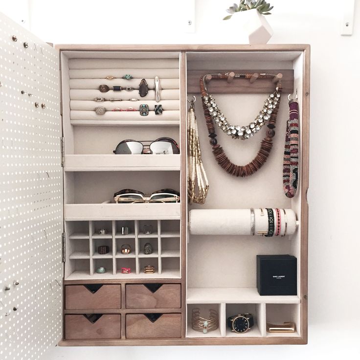 an organized closet with necklaces, bracelets and other items on display in it