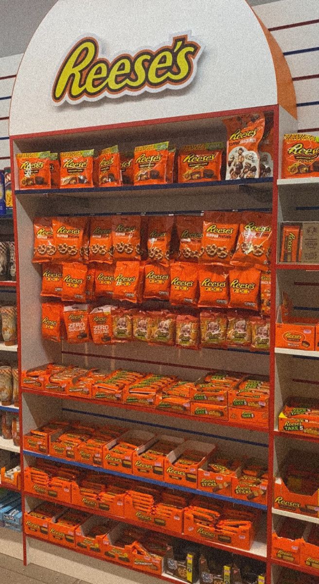 a display in a grocery store filled with lots of orange bags and food on shelves