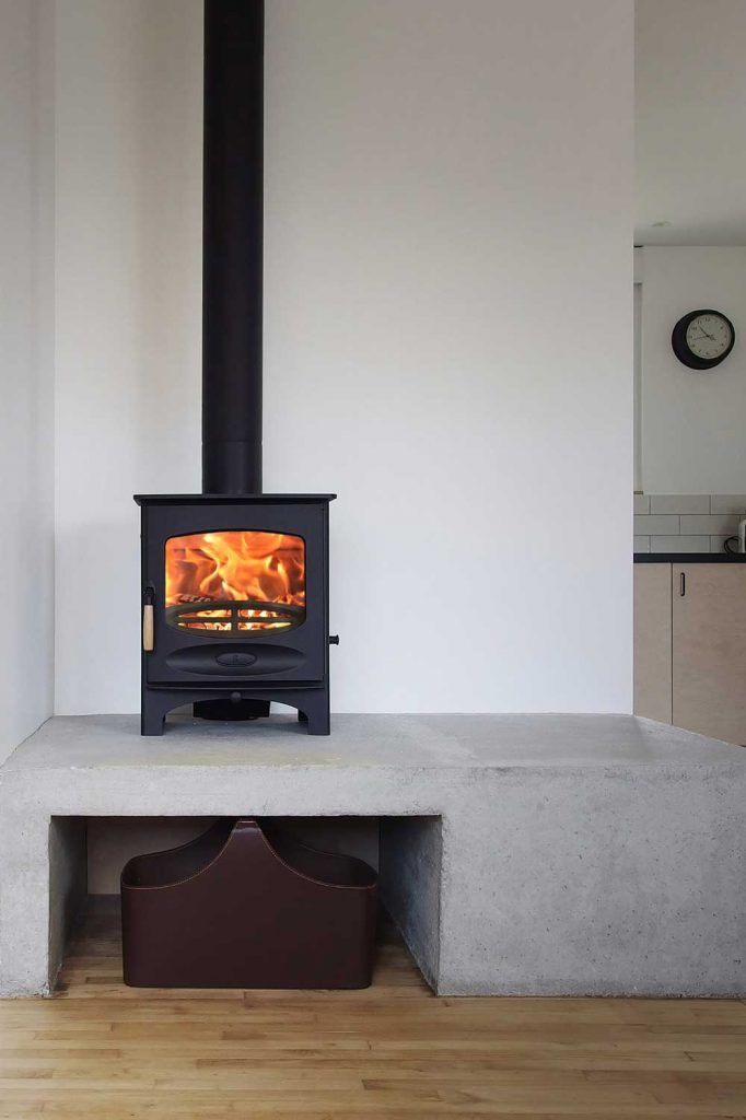 a wood burning stove sitting on top of a cement bench